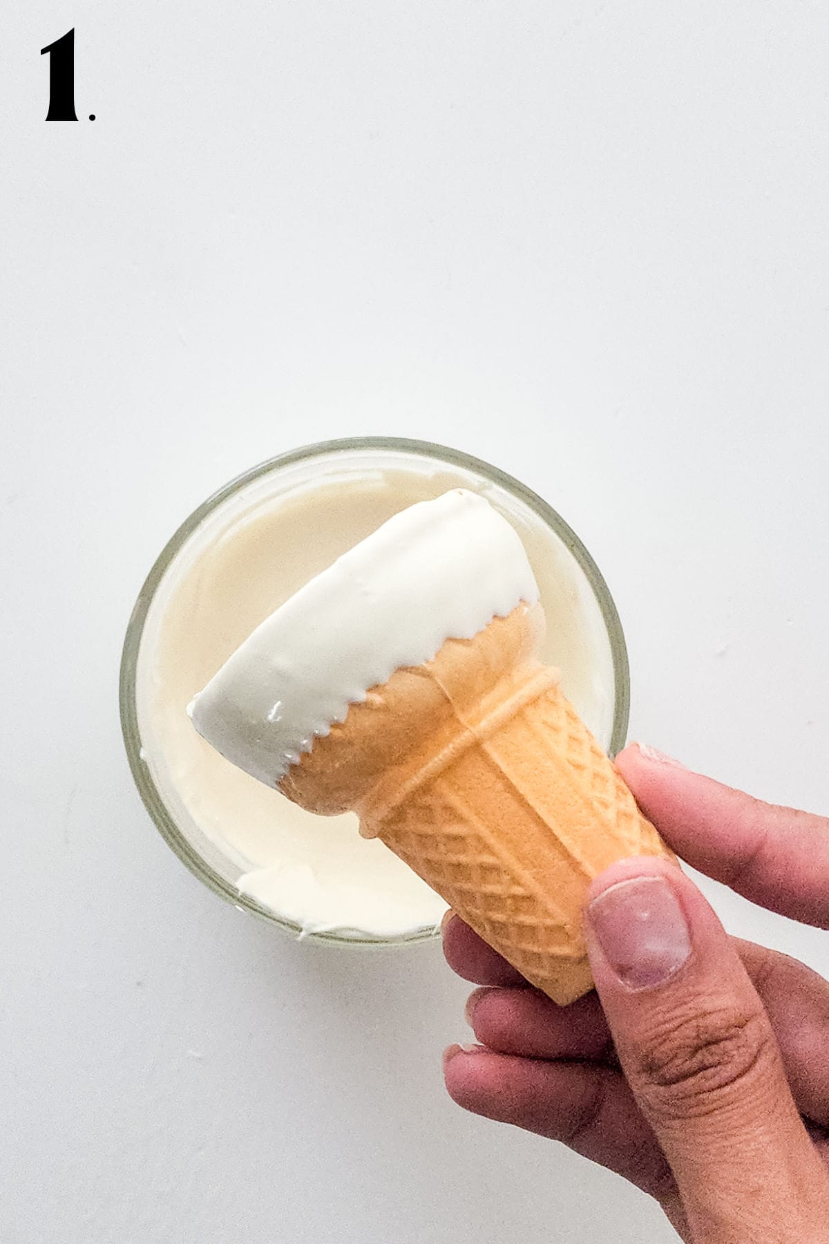 How to Make Cheesecake Mousse Cones Step 1 dipping cone in melted candy.