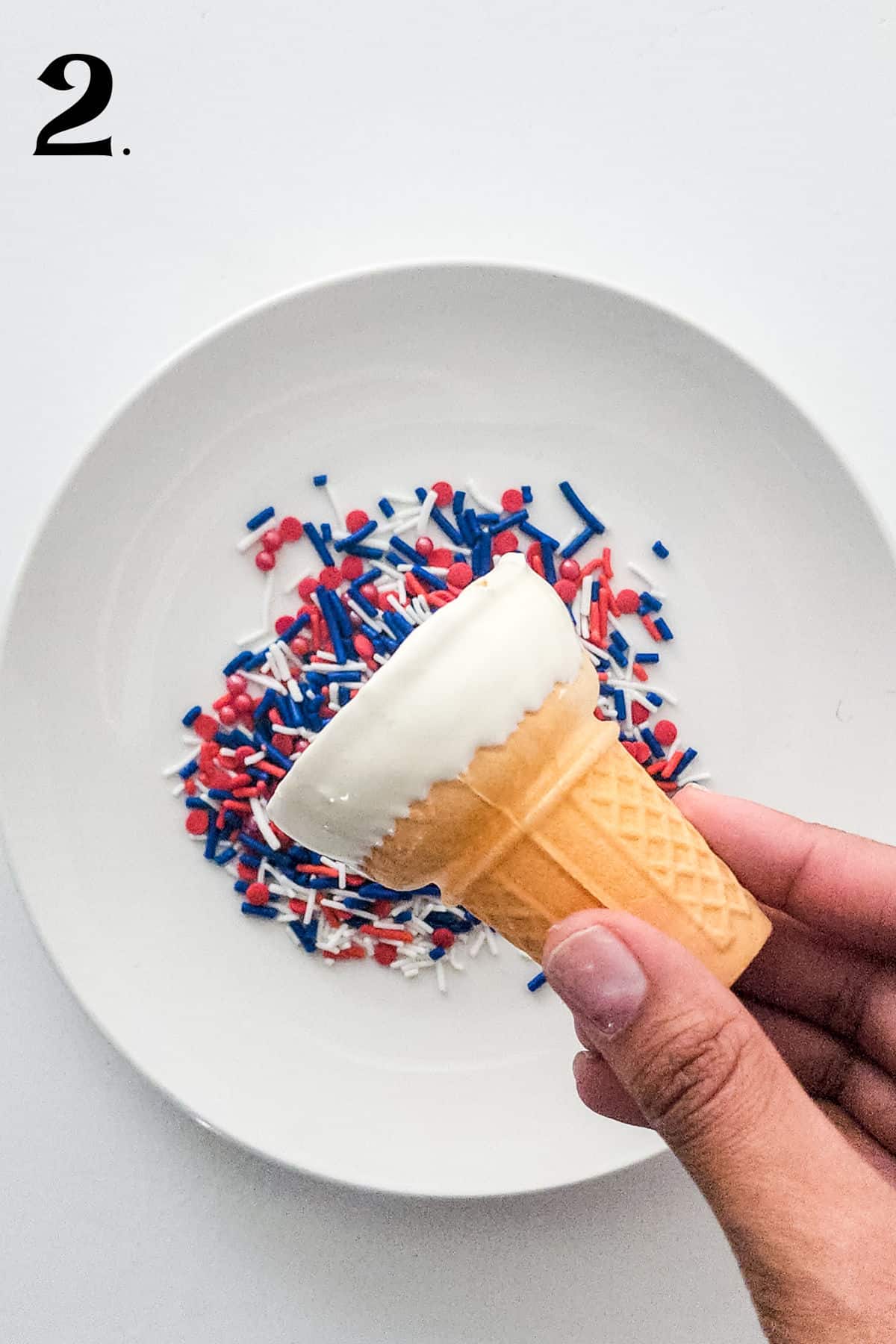 How to Make Cheesecake Mousse Cones Step 2 dipping cones in sprinkles.